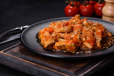 Soslu teriyaki tavuğu, susam, otlar ve baharatlar koyu beton arka planda. Asya mutfağı