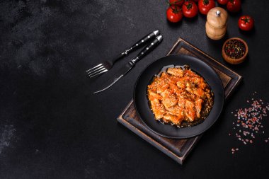 Soslu teriyaki tavuğu, susam, otlar ve baharatlar koyu beton arka planda. Asya mutfağı