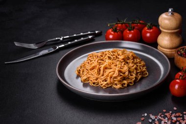 Buckwheat flour noodles with sauce, sesame, herbs and spices on a dark concrete background. Asian cuisine