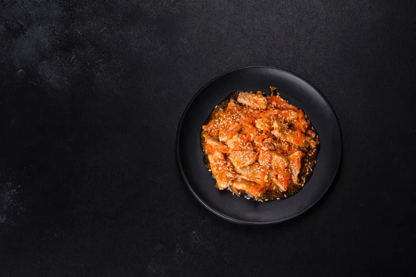 Soslu teriyaki tavuğu, susam, otlar ve baharatlar koyu beton arka planda. Asya mutfağı