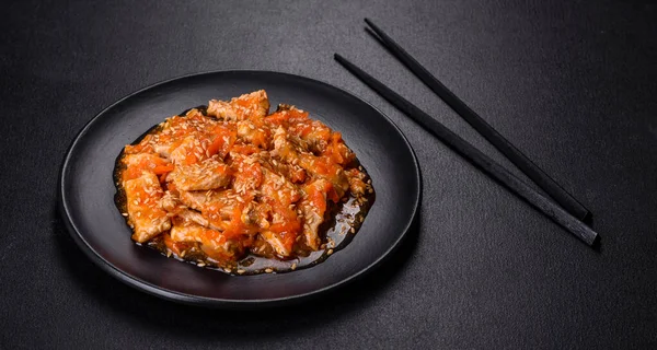 Soslu teriyaki tavuğu, susam, otlar ve baharatlar koyu beton arka planda. Asya mutfağı