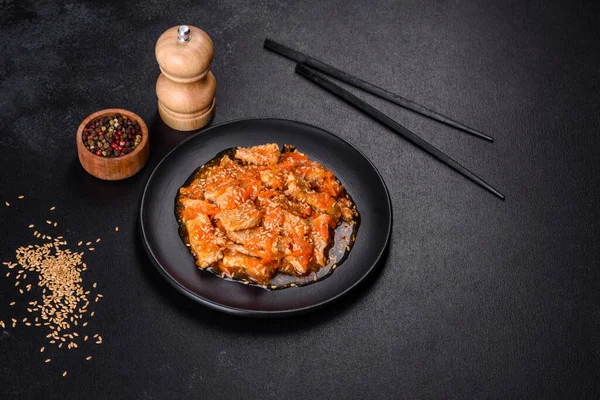 Soslu teriyaki tavuğu, susam, otlar ve baharatlar koyu beton arka planda. Asya mutfağı