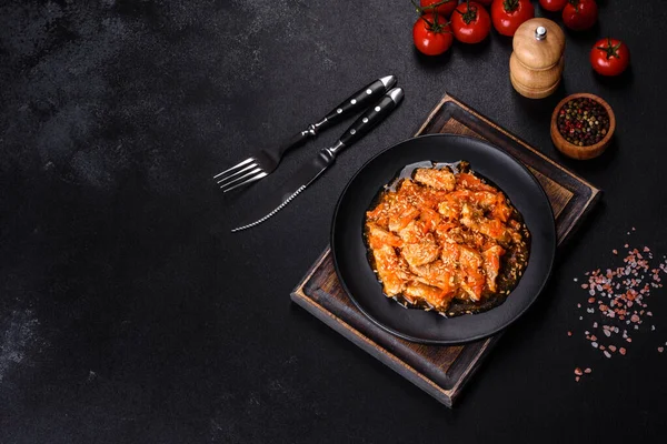 Soslu teriyaki tavuğu, susam, otlar ve baharatlar koyu beton arka planda. Asya mutfağı
