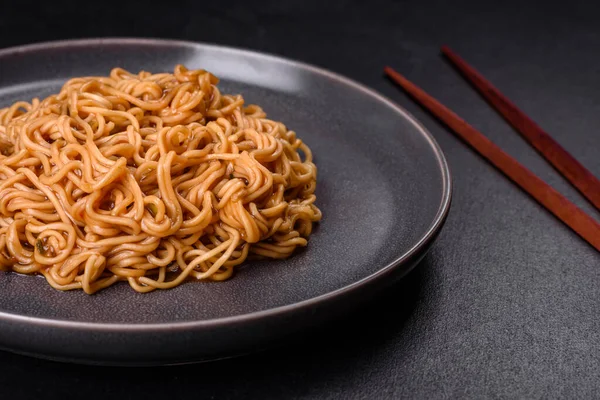 Sos, susamlı karabuğday unu eriştesi, koyu beton arka planda bitkiler ve baharatlar. Asya mutfağı