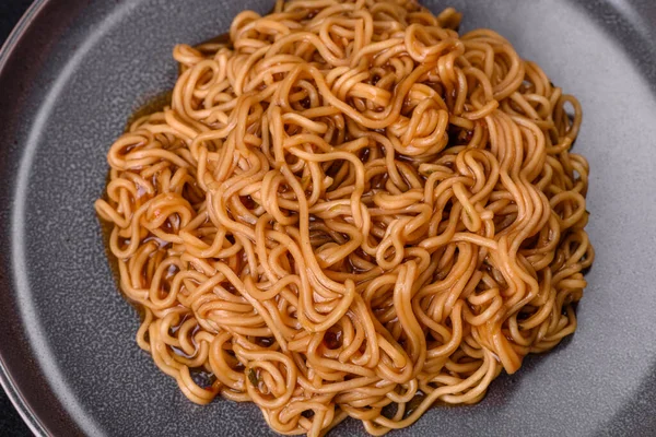 Sos, susamlı karabuğday unu eriştesi, koyu beton arka planda bitkiler ve baharatlar. Asya mutfağı