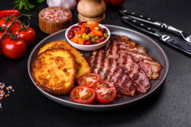 Lezzetli ızgara pastırma dilimleri, baharatlı, tuzlu, sebzeli ve çimento kaplı arka planda kızartılmış yumurta ve kızarmış ekmek.