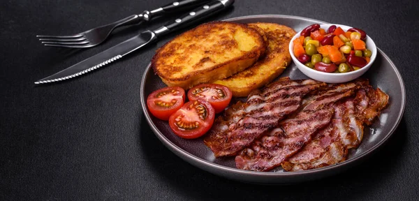 Lezzetli ızgara pastırma dilimleri, baharatlı, tuzlu, sebzeli ve çimento kaplı arka planda kızartılmış yumurta ve kızarmış ekmek.