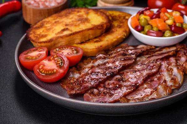 Lezzetli ızgara pastırma dilimleri, baharatlı, tuzlu, sebzeli ve çimento kaplı arka planda kızartılmış yumurta ve kızarmış ekmek.