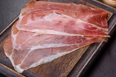 İtalyan jambonu ya da İspanyol jamonu. Koyu renk kesim tahtasında tuz ve baharatla.