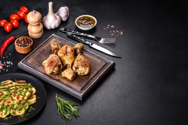 Üç tavuk budu, ahşap kesme tahtasının üzerinde çimento ve baharatla ızgara. Evde yemek pişirmek.