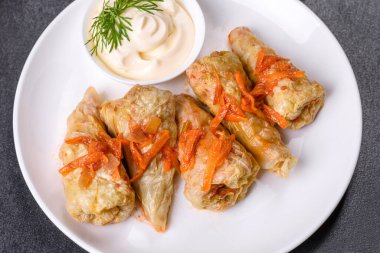 Geleneksel doldurulmuş lahana, kıyma ve pilav, domates sosunda servis edilir.