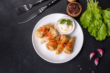 Geleneksel doldurulmuş lahana, kıyma ve pilav, domates sosunda servis edilir.