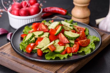 Marul, salatalık, ıspanak, domates ve bıldırcın yumurtası otlu salata ve siyah bir tabakta limon.