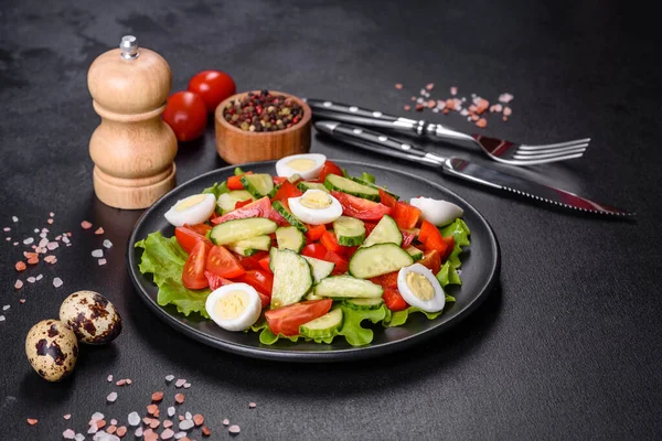 Marul, salatalık, ıspanak, domates ve bıldırcın yumurtası otlu salata ve siyah bir tabakta limon.