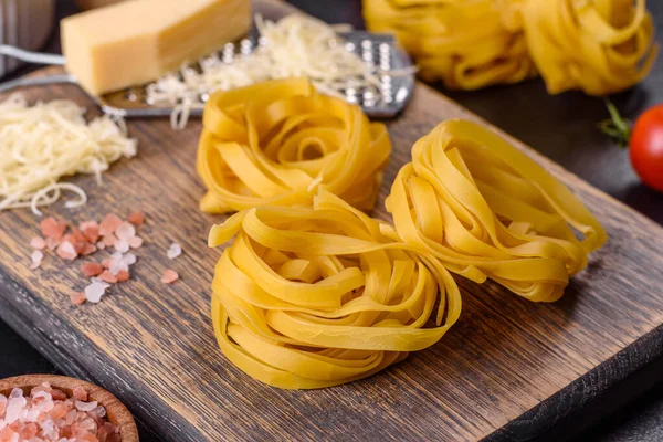 Raw Tagliatelle Paste Grated Cheese Cherry Tomatoes Spices Herbs Wooden — Stockfoto