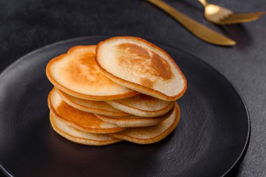 Siyah bir tabakta koyu beton bir zemine karşı nefis taze krepler. Nefis bir kahvaltı hazırlıyorum.