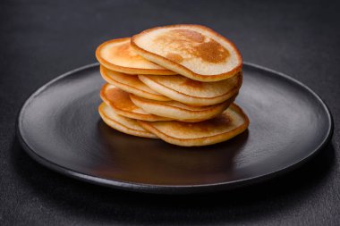 Siyah bir tabakta koyu beton bir zemine karşı nefis taze krepler. Nefis bir kahvaltı hazırlıyorum.