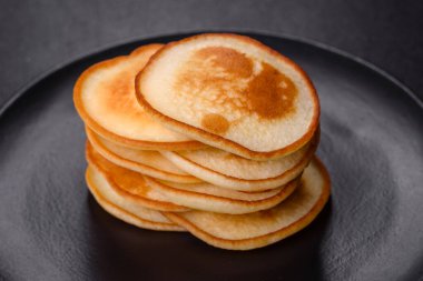 Siyah bir tabakta koyu beton bir zemine karşı nefis taze krepler. Nefis bir kahvaltı hazırlıyorum.