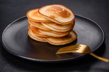 Siyah bir tabakta koyu beton bir zemine karşı nefis taze krepler. Nefis bir kahvaltı hazırlıyorum.