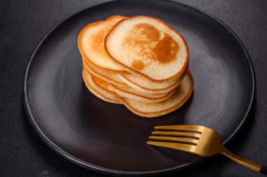 Siyah bir tabakta koyu beton bir zemine karşı nefis taze krepler. Nefis bir kahvaltı hazırlıyorum.