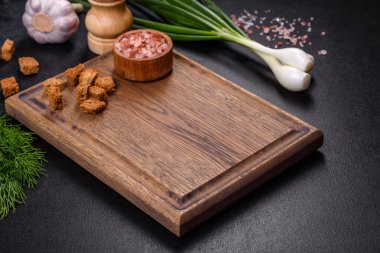 Tahta bir tahtanın üzerinde, üzerinde ekmek kırıntıları, baharatlar ve otlarla birlikte koyu beton bir zemin üzerinde taze, lezzetli bir mantar püresi çorbası. Vejetaryen mutfağı