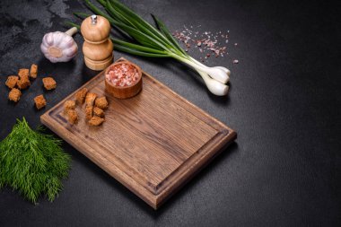 Tahta bir tahtanın üzerinde, üzerinde ekmek kırıntıları, baharatlar ve otlarla birlikte koyu beton bir zemin üzerinde taze, lezzetli bir mantar püresi çorbası. Vejetaryen mutfağı