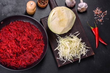 Geleneksel Ukrayna borşunun hazırlanmasında kullanılan malzemeler olarak bir tavada doğranmış pancar, baharatlar ve otlar.