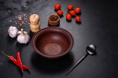 İçinde bıçak, çatal ya da kaşık olan boş bir tabak. Koyu beton arka planda tahta kesim tahtası var. Ev aletleri ve ev yemeği malzemelerinin hazırlanması