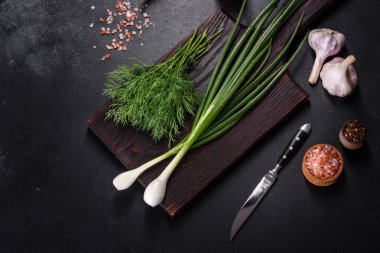 Taze soğan, dereotu, sarımsak ve acı biberin yanı sıra baharatlar ve baharatlar, geleneksel Ukrayna borsasının hazırlanmasında kullanılacak malzemeler olarak ahşap bir kesme tahtasının üzerinde.