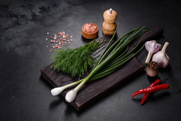 Taze soğan, dereotu, sarımsak ve acı biberin yanı sıra baharatlar ve baharatlar, geleneksel Ukrayna borsasının hazırlanmasında kullanılacak malzemeler olarak ahşap bir kesme tahtasının üzerinde.