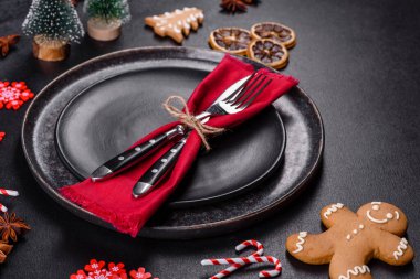 Boş siyah seramik tabağı, köknar ağacı dalı ve siyah aksesuarlı siyah taş zemin