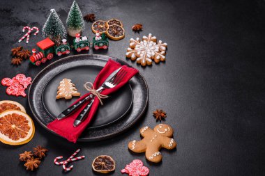 Boş siyah seramik tabağı, köknar ağacı dalı ve siyah aksesuarlı siyah taş zemin