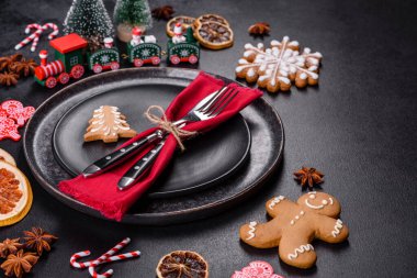 Boş siyah seramik tabağı, köknar ağacı dalı ve siyah aksesuarlı siyah taş zemin