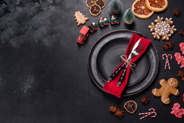 Boş siyah seramik tabağı, köknar ağacı dalı ve siyah aksesuarlı siyah taş zemin