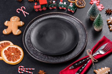 Boş siyah seramik tabağı, köknar ağacı dalı ve siyah aksesuarlı siyah taş zemin