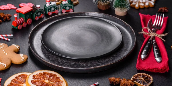 Boş siyah seramik tabağı, köknar ağacı dalı ve siyah aksesuarlı siyah taş zemin