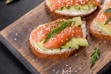 Açık sandviç ya da tost. Somon, avokado ve susamlı tahıl ekmeği. Sağlıklı çerez, yağ ve omega 3 kaynağı