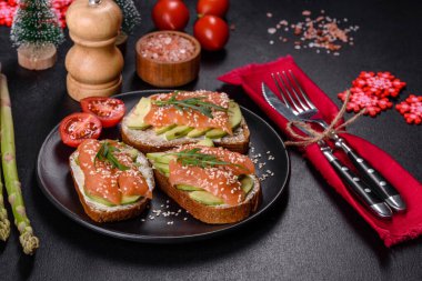 Açık sandviç ya da tost. Somon, avokado ve susamlı tahıl ekmeği. Sağlıklı çerez, yağ ve omega 3 kaynağı noel masasında.