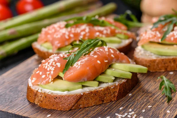 Open sandwich or toast. Grain bread with salmon, avocado and sesame seeds. Healthy snack, fat and omega 3 source