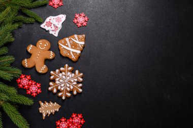 Koyu beton zeminde Noel ağacı dalları olan nefis zencefilli çörek. Noel masası için dekorasyon hazırlıyorum.