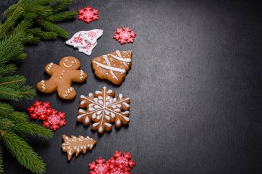 Koyu beton zeminde Noel ağacı dalları olan nefis zencefilli çörek. Noel masası için dekorasyon hazırlıyorum.