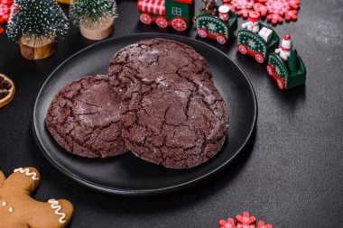 İçinde Noel oyuncakları, kurutulmuş turunçgiller ve oyuncak Noel ağaçları olan koyu betondan yapılmış lezzetli çikolatalı bisküviler. Festival masası hazırlıyorum.