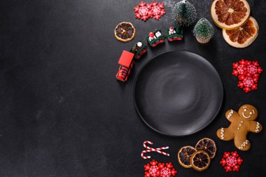 İçinde Noel oyuncakları, kurutulmuş turunçgiller ve oyuncak Noel ağaçları olan koyu betondan yapılmış lezzetli çikolatalı bisküviler. Festival masası hazırlıyorum.