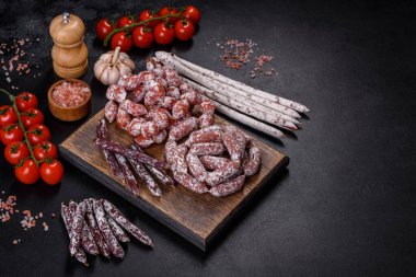 Spanish Fuet sausage slices, on a dark concrete background