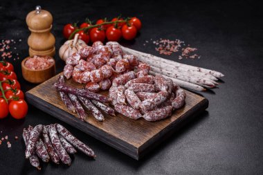 İspanyol Fuet sosisleri, koyu beton arka planda.