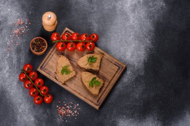 Fresh homemade chicken liver pate on bread over grey background