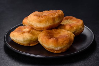 Traditional homemade pies with cabbage and sauerkraut on the plate on a concrete table