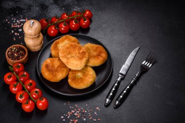 Traditional homemade pies with cabbage and sauerkraut on the plate on a concrete table
