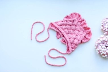 Pink cap for a young child. Clothing in the first days of the child's life. Hat tied with your own hands