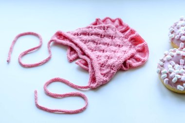 Pink cap for a young child. Clothing in the first days of the child's life. Hat tied with your own hands
